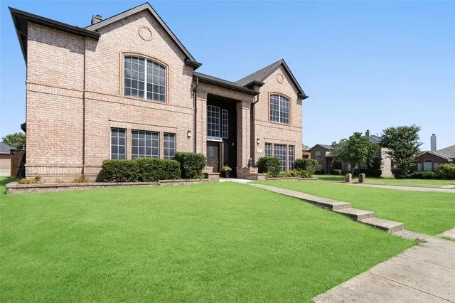 a front view of a house with a yard and trees