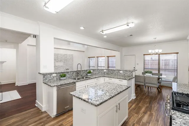 a dining hall with stainless steel appliances granite countertop a stove and chairs