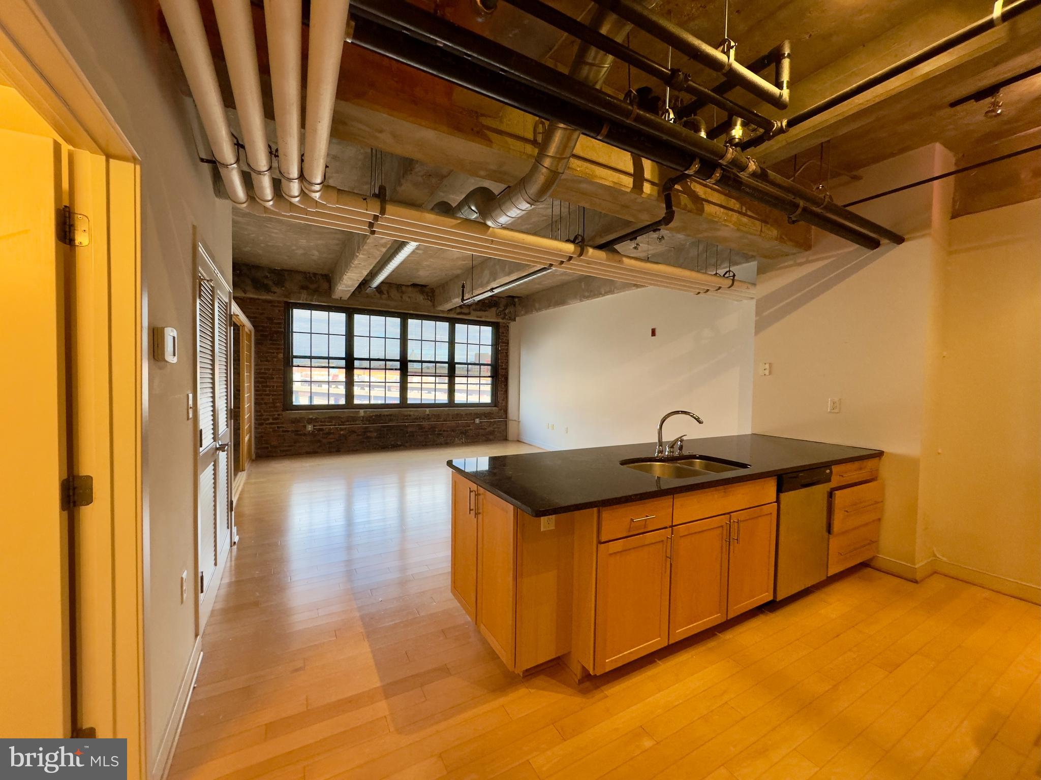 234 Holliday Street, Unit 403 Baltimore, MD 21202 - Photo 3 of 11 a kitchen with granite countertop a sink and a stove next to a window
