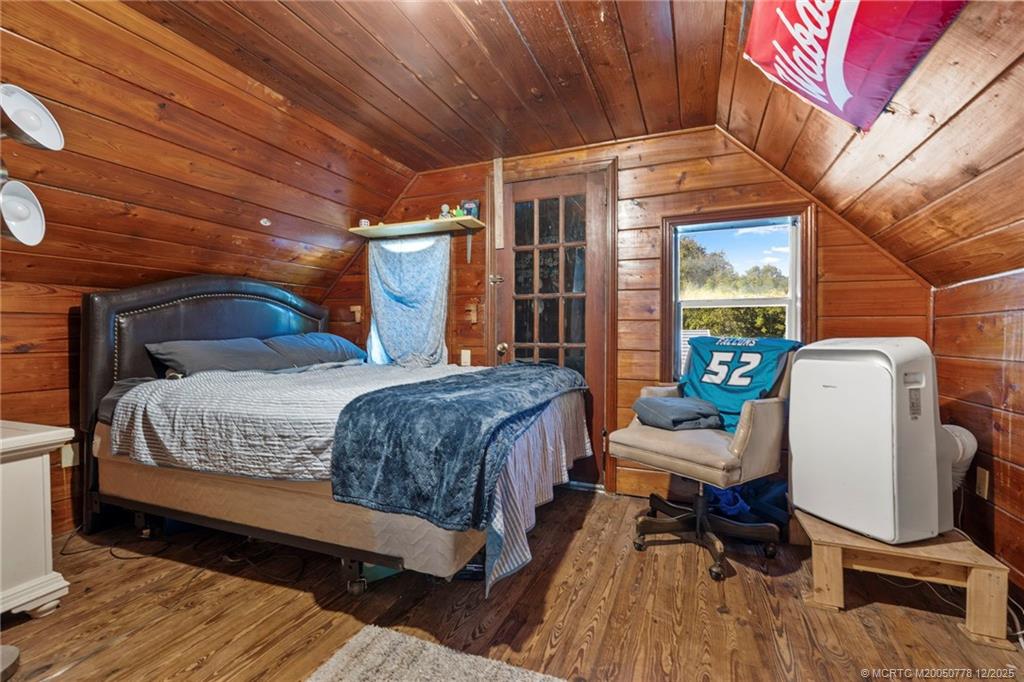 1699 Northwest Britt Road Stuart, FL 34994 - Photo 20 of 54 a bedroom with a bed a chair and potted plant on the table