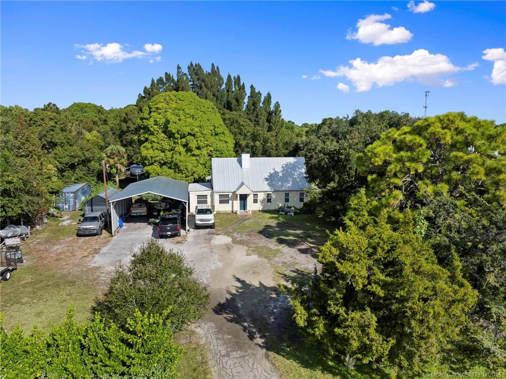 1699 Northwest Britt Road Stuart, FL 34994 - Photo 38 of 54 a view of a swimming pool and trees in the background