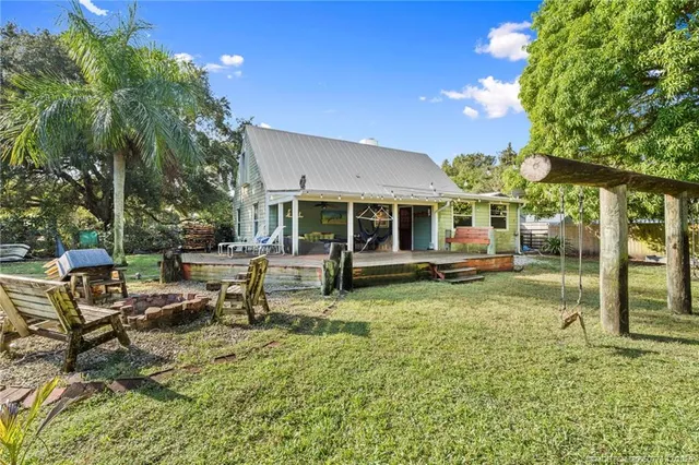 a view of a house with backyard and sitting area