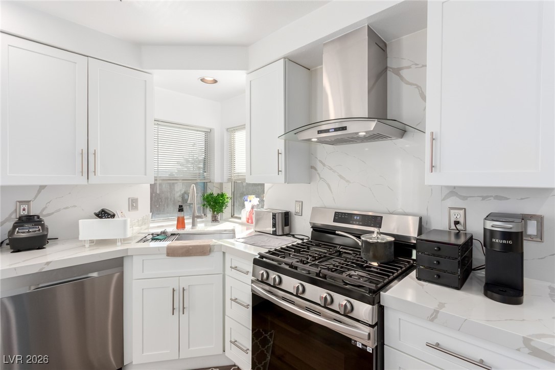 906 Ambusher Street Henderson, NV 89014 - Photo 12 of 38 Kitchen featuring stainless steel appliances, white cabinets, and light stone countertops
