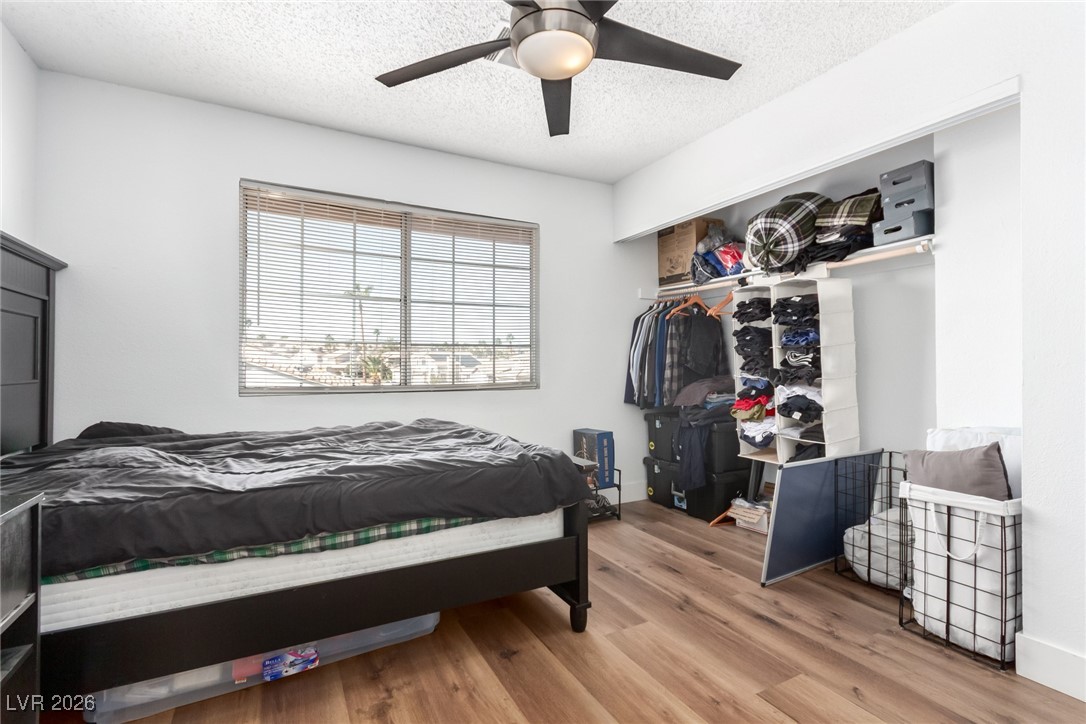 906 Ambusher Street Henderson, NV 89014 - Photo 21 of 38 Bedroom featuring wood finished floors, a textured ceiling, ceiling fan, and a closet