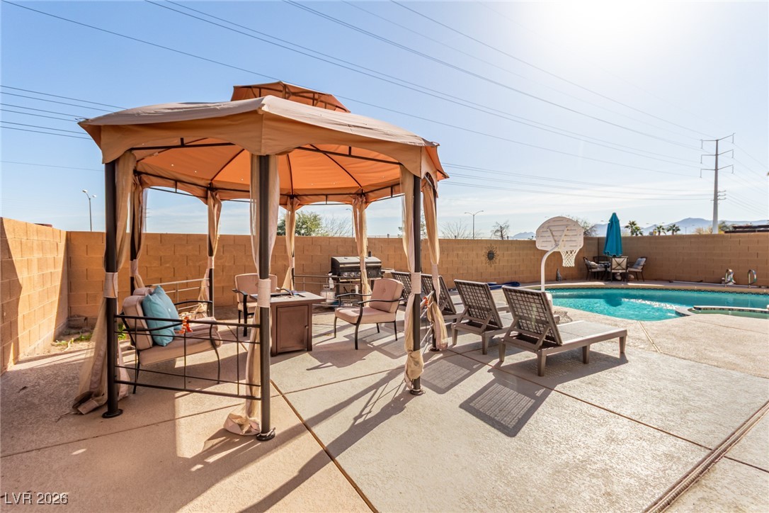 906 Ambusher Street Henderson, NV 89014 - Photo 28 of 38 Fenced backyard with a gazebo, a patio, an outdoor living space with a fire pit, and a pool with connected hot tub