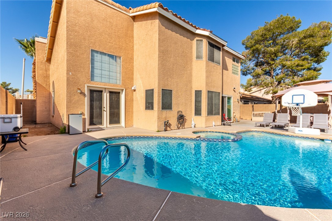 906 Ambusher Street Henderson, NV 89014 - Photo 29 of 38 Combined pool / hot tub with french doors, a fenced backyard, and a patio area