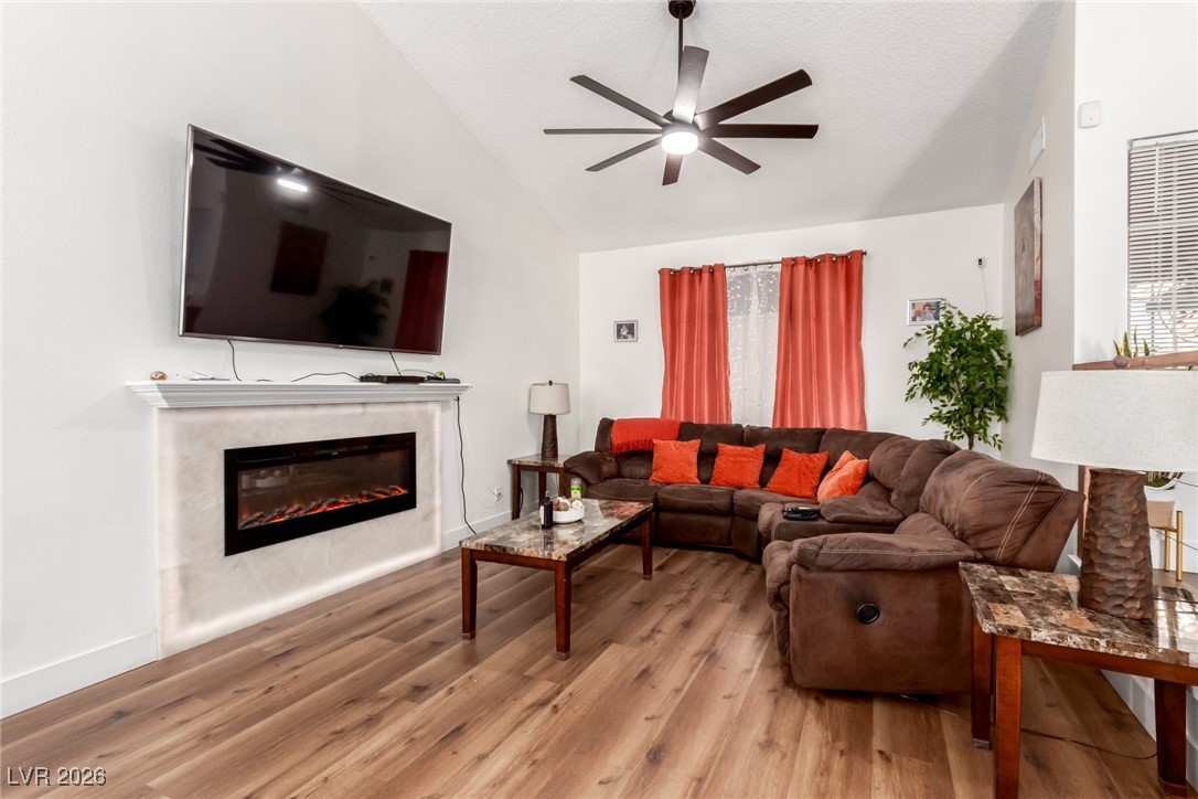 906 Ambusher Street Henderson, NV 89014 - Photo 7 of 38 Living area featuring a fireplace, light wood-style flooring, and ceiling fan