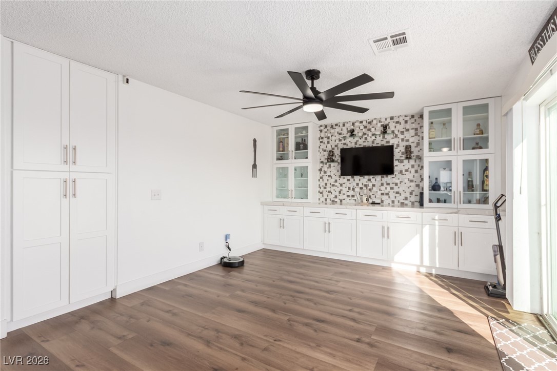 906 Ambusher Street Henderson, NV 89014 - Photo 10 of 38 Unfurnished living room featuring dark wood-type flooring, ceiling fan, and a textured ceiling