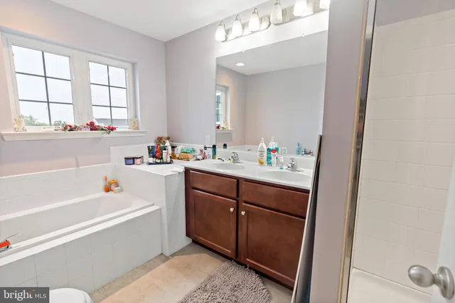 a bathroom with a tub sink and a window