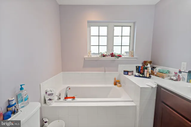 a bathroom with a window a sink and a bath tub