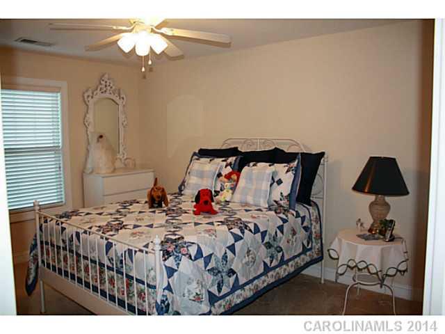 1032 Ridgehaven Road Waxhaw, NC 28173 - Photo 11 of 16 a bedroom with a bed a dresser and a chandelier