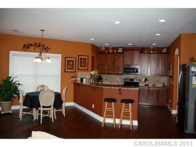 1032 Ridgehaven Road Waxhaw, NC 28173 - Photo 7 of 16 a kitchen with stainless steel appliances kitchen island granite countertop a refrigerator a stove a sink dishwasher with a dining table and chairs