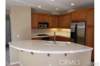 a kitchen with kitchen island a stove a sink and a refrigerator