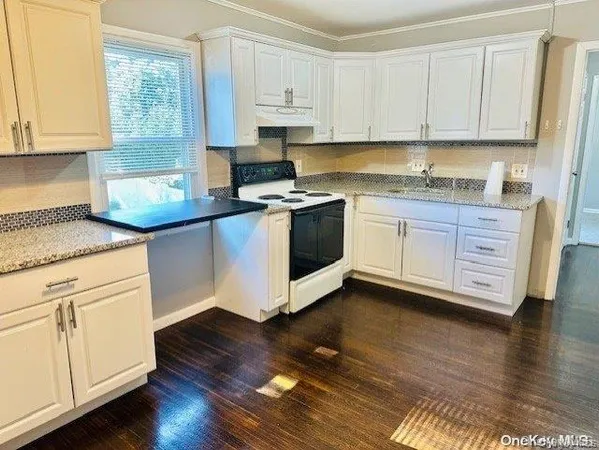 a kitchen with granite countertop wooden cabinets and white appliances