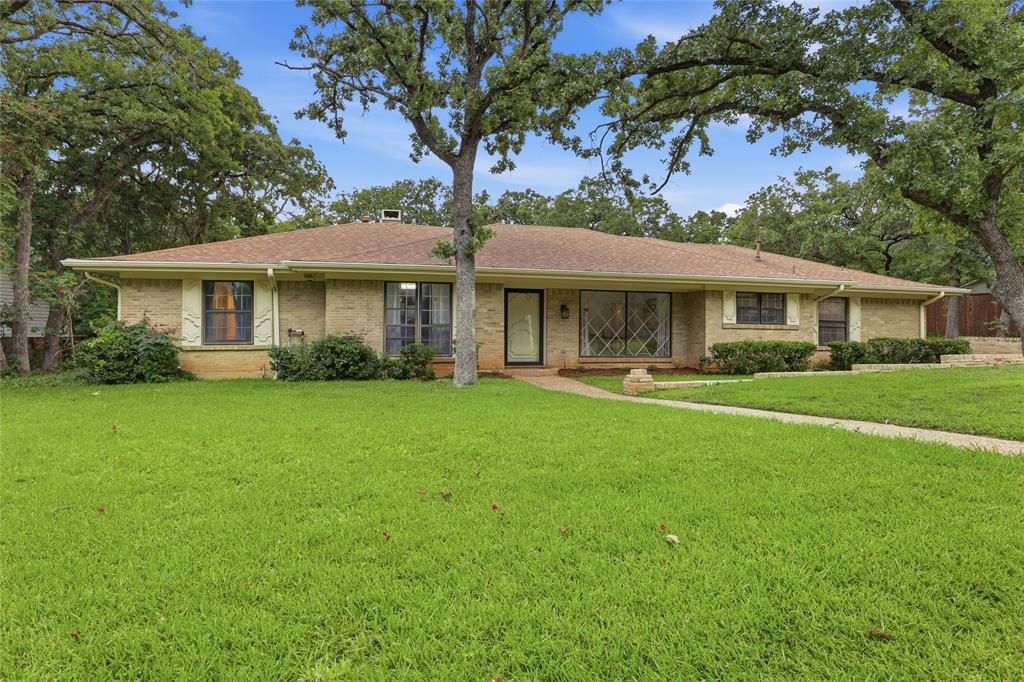 823 Ridgecrest Circle Denton, TX 76205 - Photo 2 of 40 Single-story brick residence featuring a brown shingle roof, a front walkway, mature trees, and established landscaping