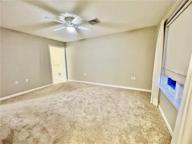 an empty room with a ceiling fan and a window