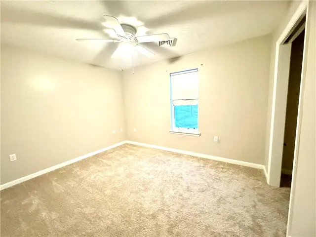 an empty room with a empty space and a ceiling fan