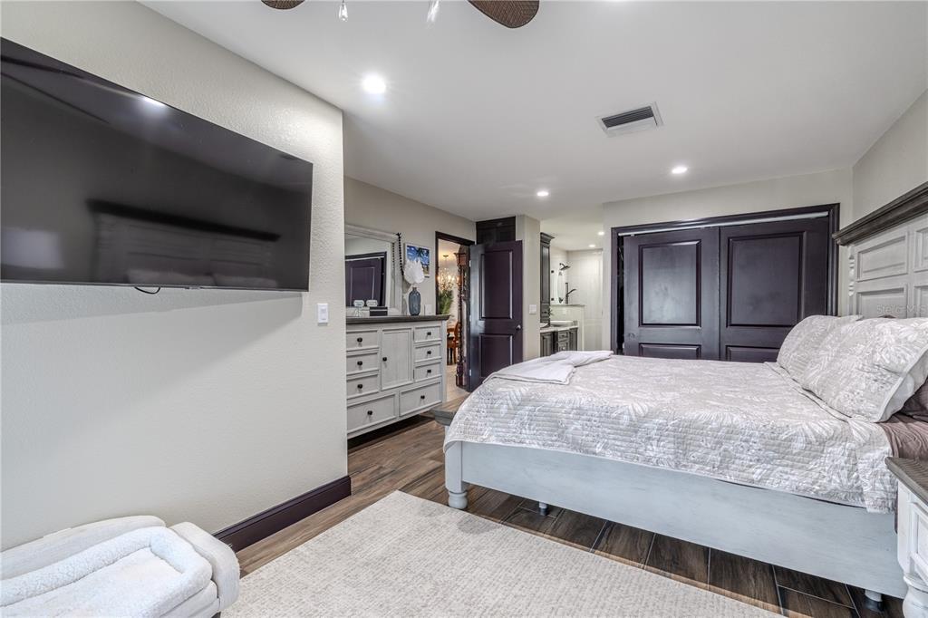 345 Boca Ciega Point Boulevard St. Petersburg, FL 33708 - Photo 24 of 64 a spacious bedroom with a bed and a flat screen tv