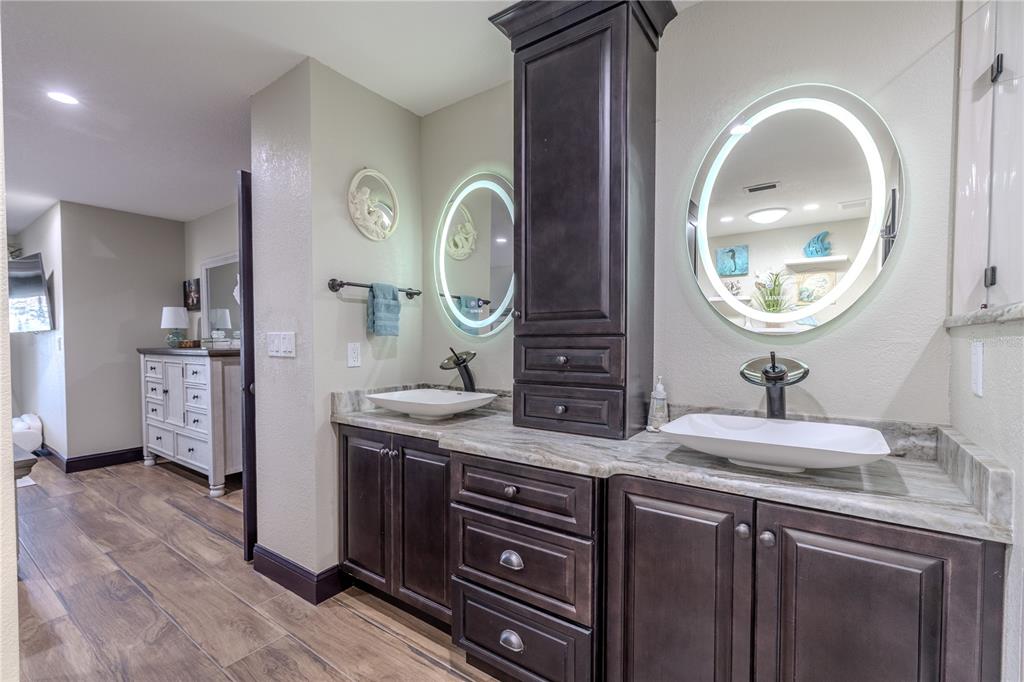 345 Boca Ciega Point Boulevard St. Petersburg, FL 33708 - Photo 25 of 64 a bathroom with a granite countertop sink and a mirror