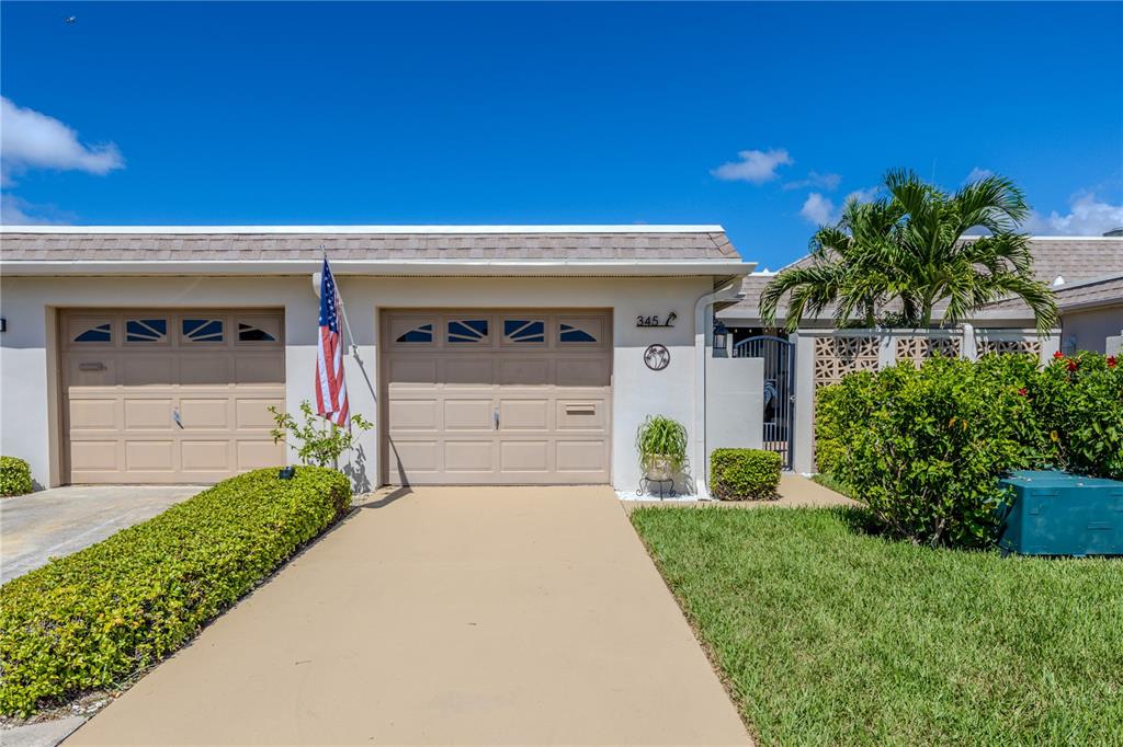 345 Boca Ciega Point Boulevard St. Petersburg, FL 33708 - Photo 3 of 64 a front view of a house with a yard and garage