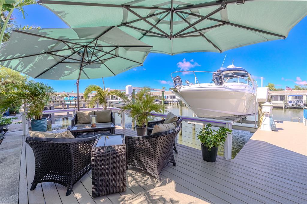345 Boca Ciega Point Boulevard St. Petersburg, FL 33708 - Photo 34 of 64 a view of a patio with a table and chairs under an umbrella