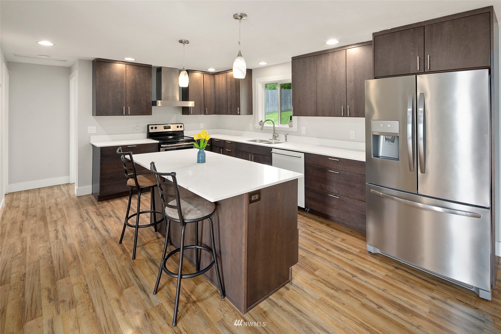 14416 Connelly Road Snohomish, WA 98296 - Photo 2 of 24 a kitchen with stainless steel appliances a refrigerator and a wooden floor
