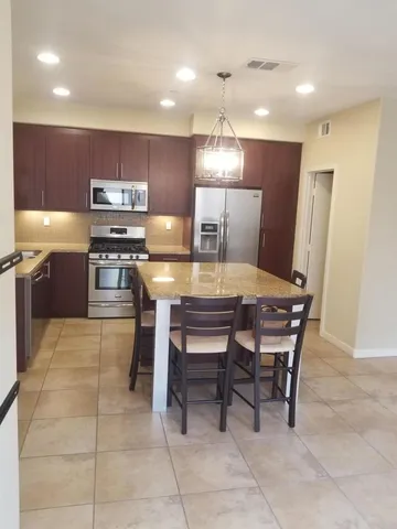 a kitchen with a table chairs microwave and refrigerator