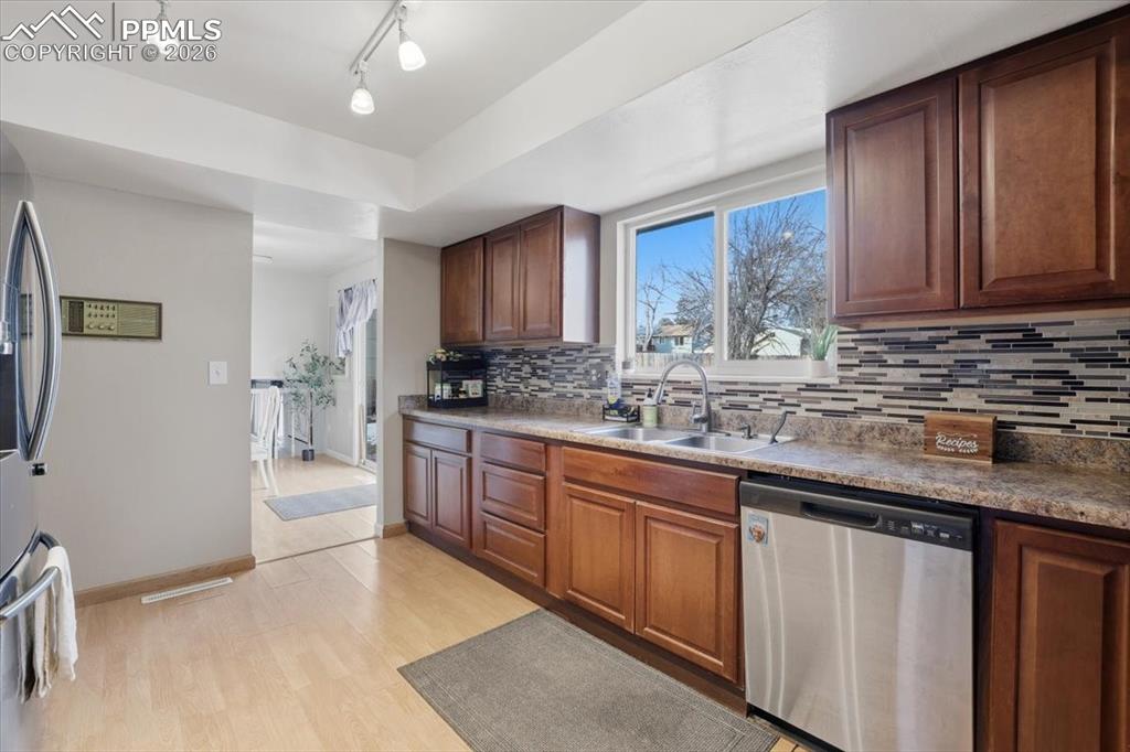 2918 Flintridge Square Colorado Springs, CO 80918 - Photo 15 of 49 a kitchen with stainless steel appliances granite countertop a stove a sink dishwasher and a refrigerator with wooden cabinets