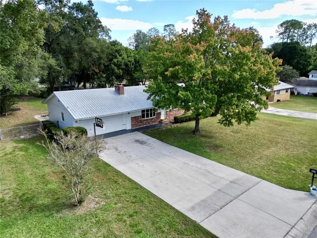 an aerial view of a house with swimming pool and garden