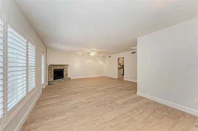 a view of empty room with wooden floor and fireplace