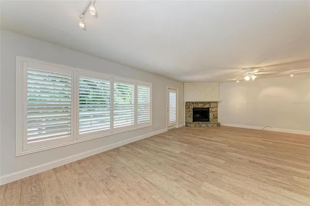 a view of empty room with wooden floor and fireplace