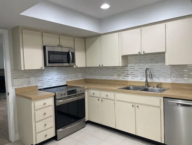 a kitchen with granite countertop white cabinets white stainless steel appliances and sink