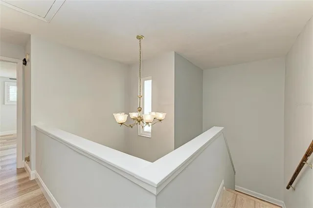 a view of an empty room and chandelier fan