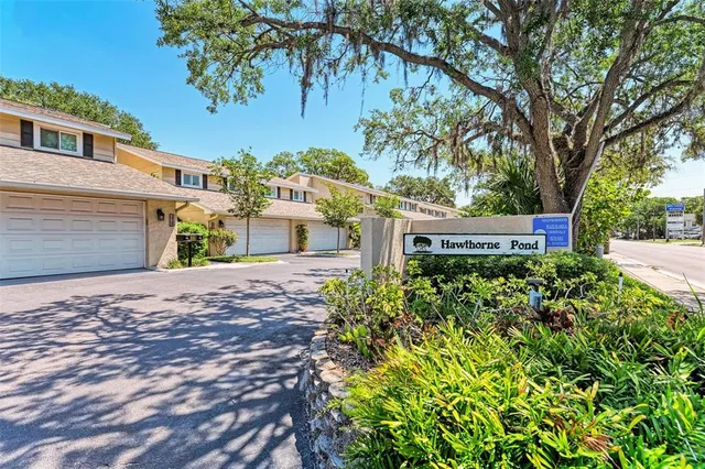 a view of a house with a yard and a tree