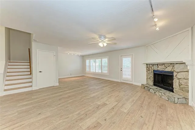 an empty room with windows and fireplace