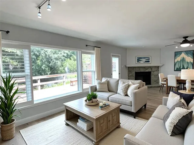 a living room with furniture large window and a fireplace