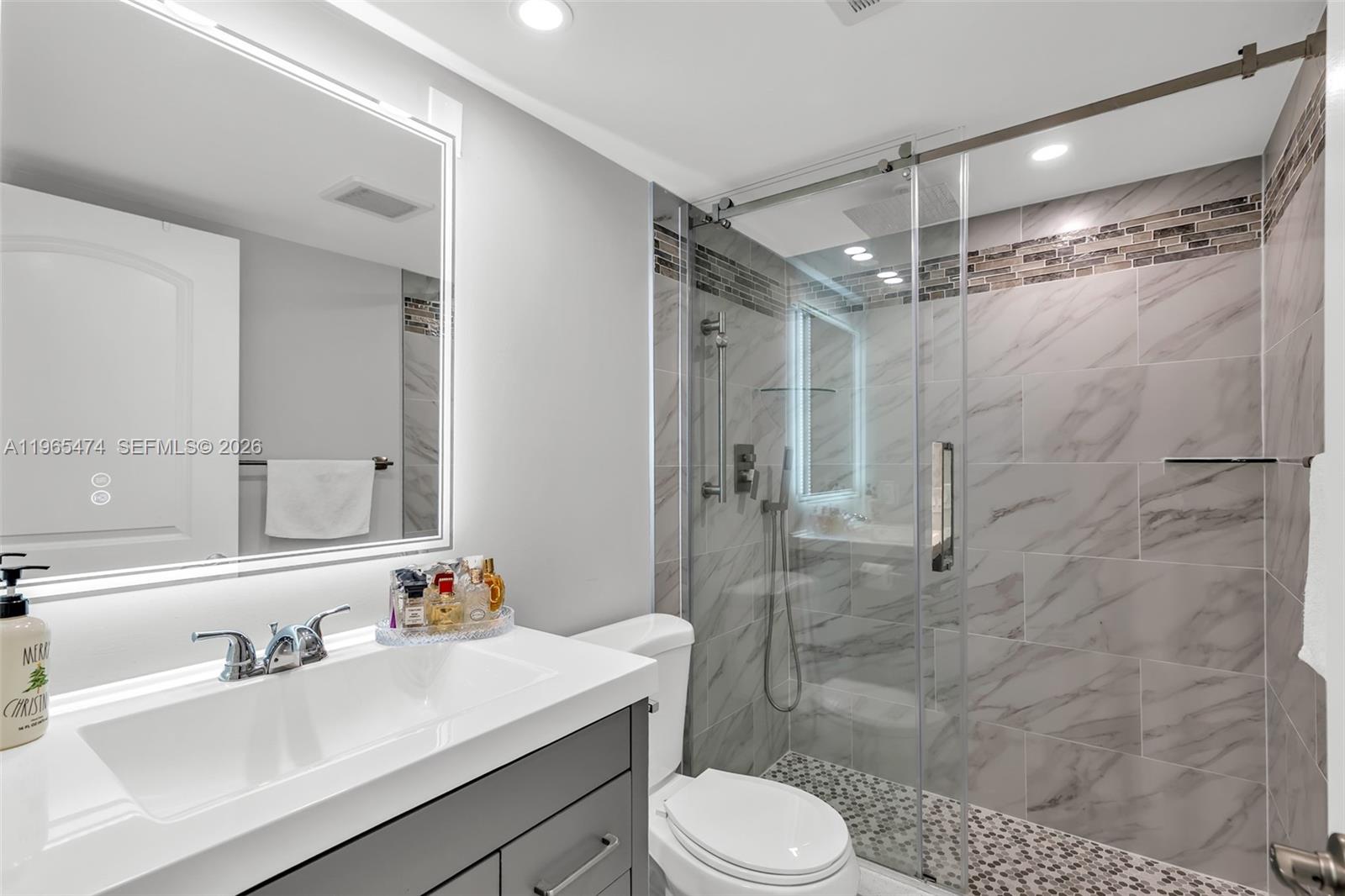 152 Dorset D, Unit 152 Boca Raton, FL 33434 - Photo 13 of 31 a bathroom with a sink toilet a mirror and shower