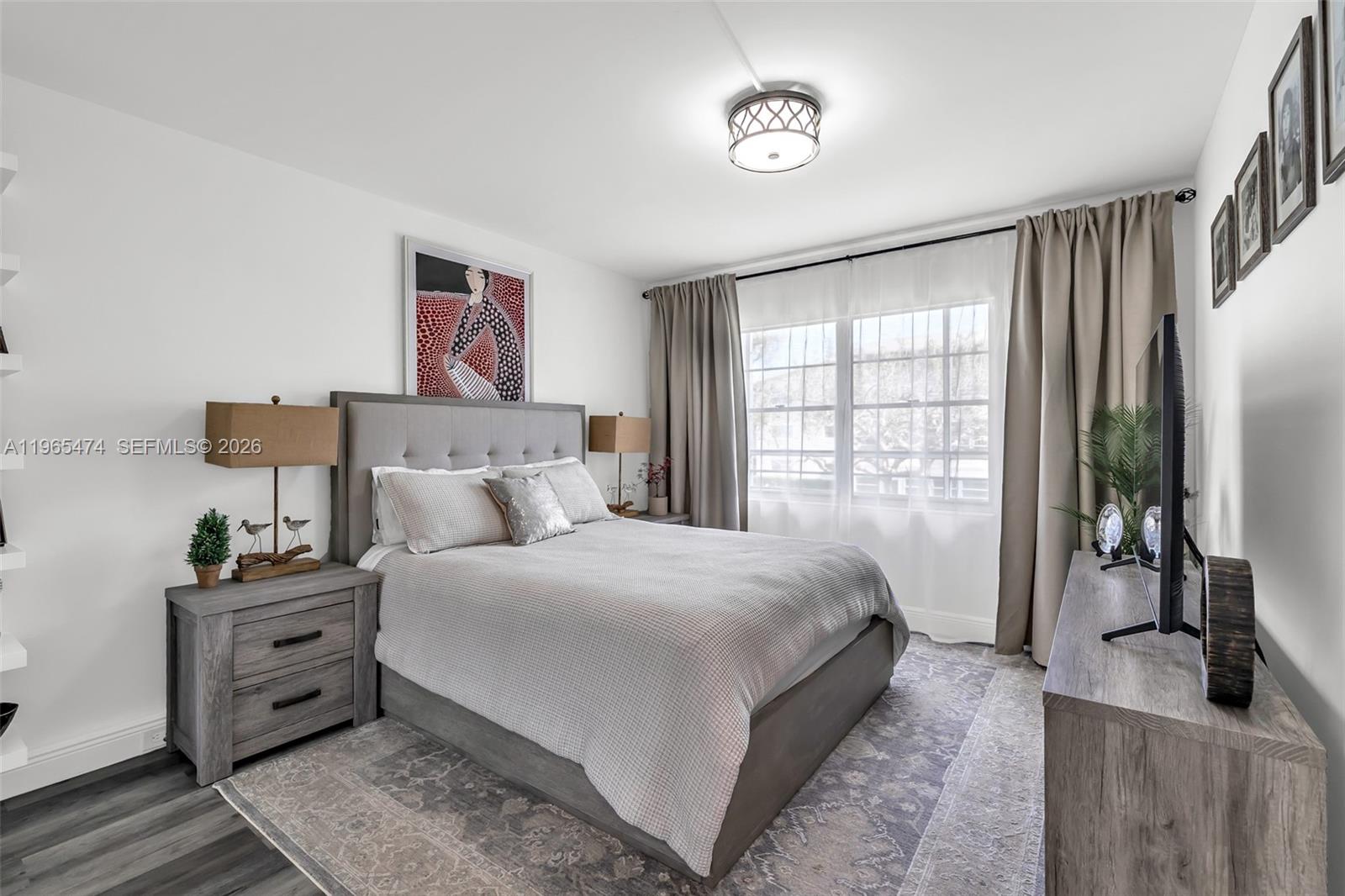 152 Dorset D, Unit 152 Boca Raton, FL 33434 - Photo 14 of 31 a bedroom with a large bed and a flat tv screen on dresser