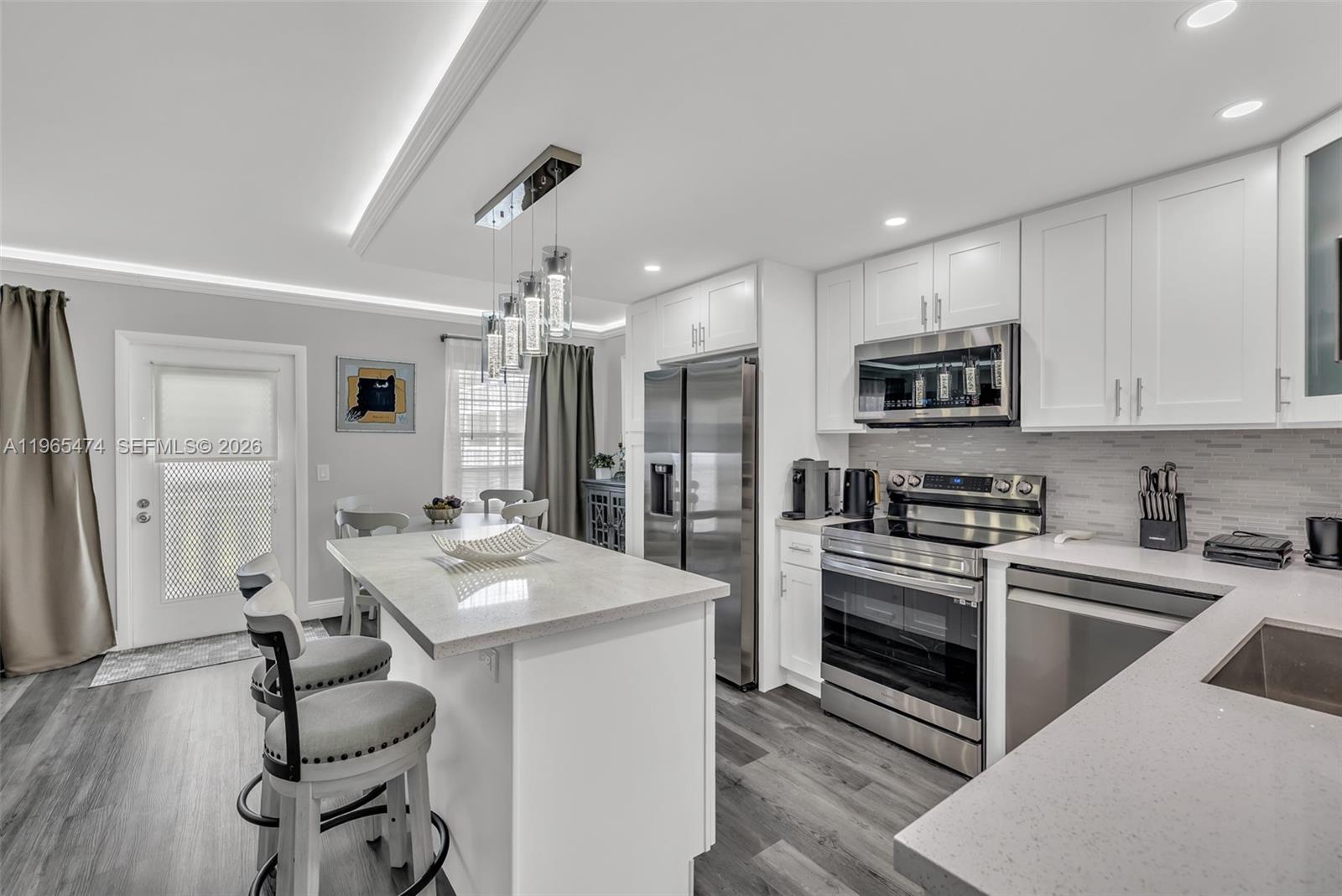 152 Dorset D, Unit 152 Boca Raton, FL 33434 - Photo 8 of 31 a kitchen with stainless steel appliances kitchen island a sink stove and refrigerator