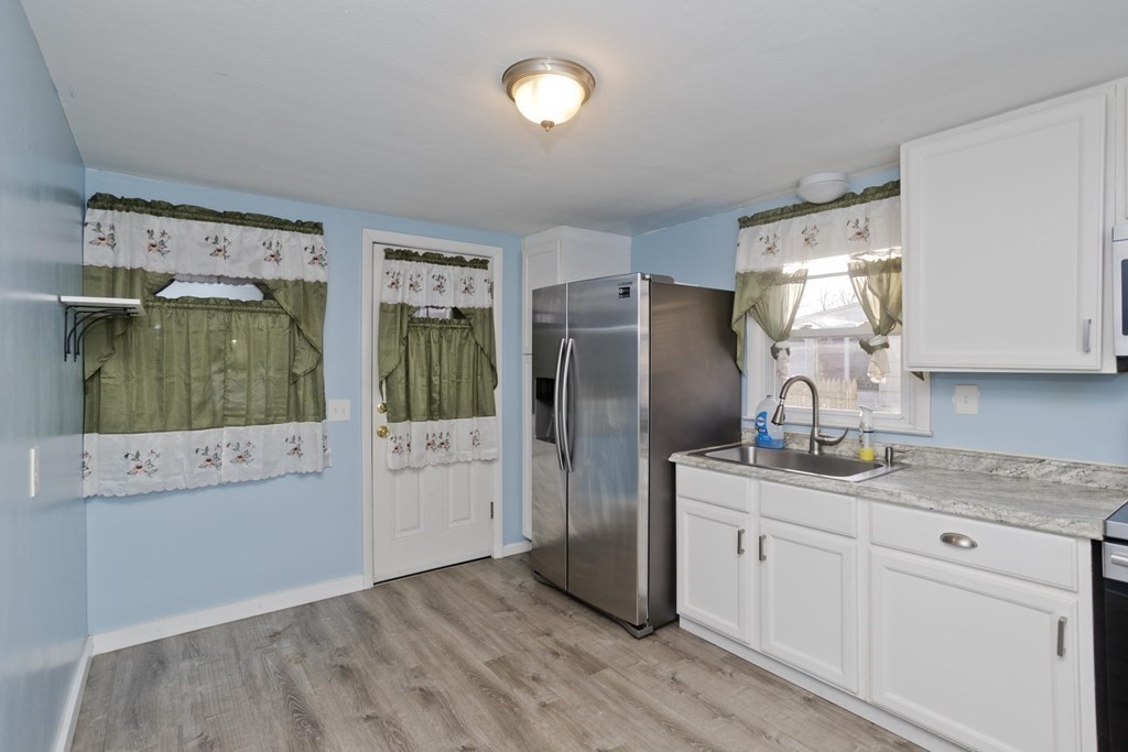 33 Campechi Street Springfield, MA 01104 - Photo 15 of 37 a kitchen with a refrigerator a sink and dishwasher with wooden floor