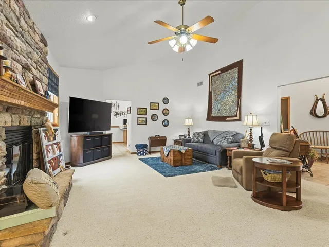 a living room with furniture a flat screen tv and kitchen view