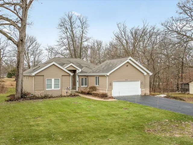 a front view of house with yard and trees around
