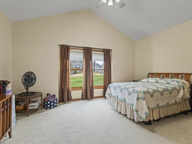 a spacious bedroom with a bed and a chandelier