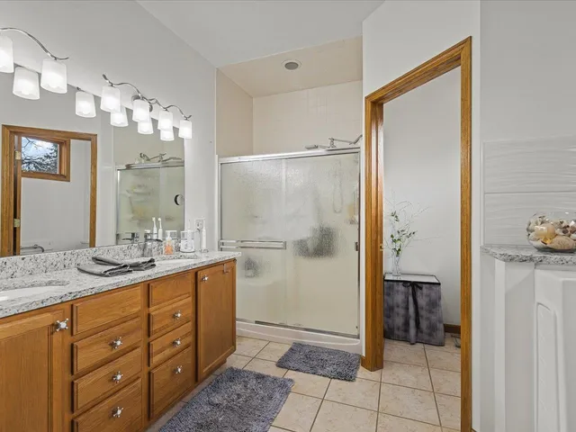 a bathroom with a granite countertop sink a mirror and a shower