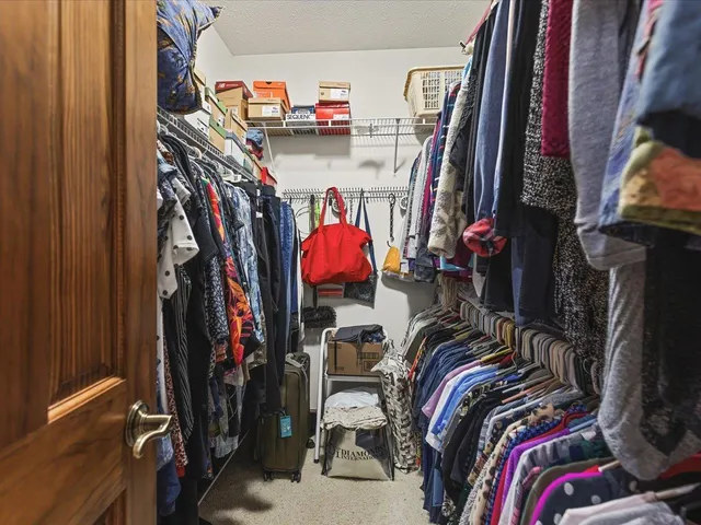 a view of walk in closet with clothes