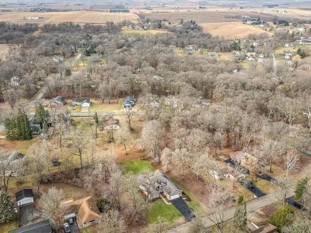 a view of a lake with beach and large trees