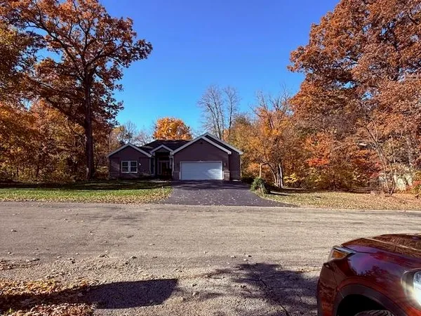 a view of a house with a wooden deck and a yard