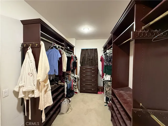 a view of walk in closet with clothes