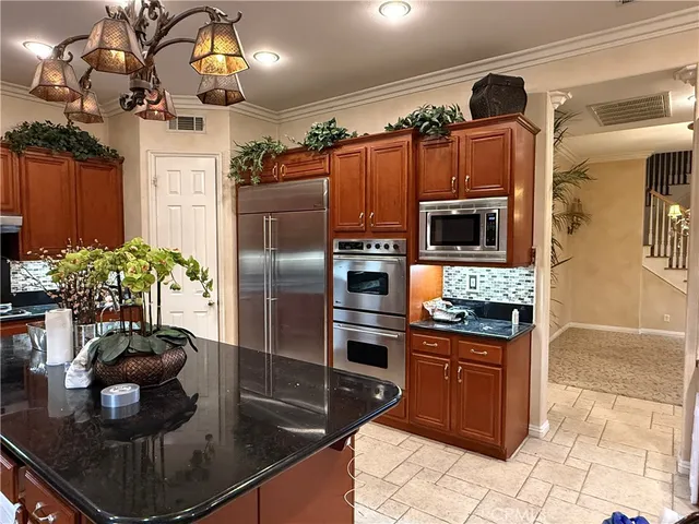 a kitchen with stainless steel appliances granite countertop a sink a stove and a refrigerator