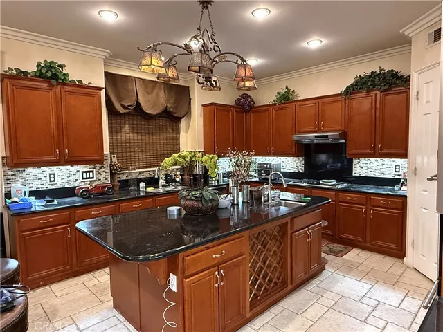 a kitchen with stainless steel appliances granite countertop a sink a stove and a wooden cabinets